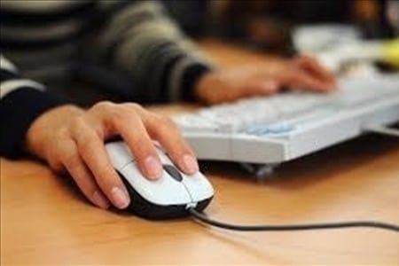 Generic person at computer with hand on mouse
