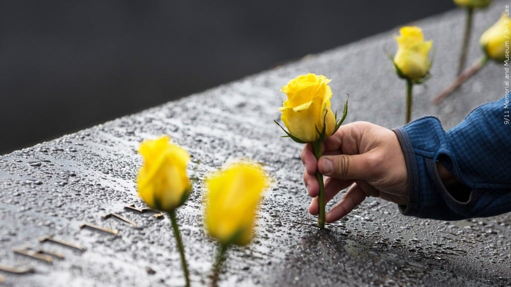 Person placing yellow rose on the National September 11 Memorial & Museum