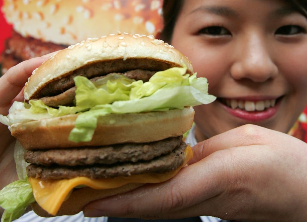 A Mcdonald's Employee Displays A Mega Mac Burger At A Mcdonald's Outlet In Tokyo