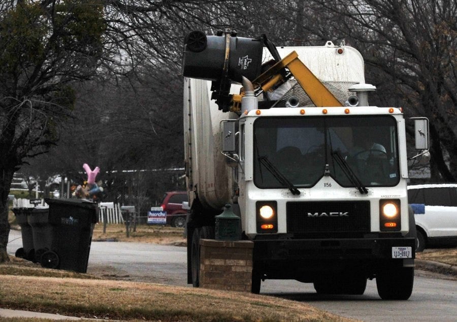A Wichita Falls Sanitation Truck Picks Up A Roll Off Trash Can On Pennsylvania Road.