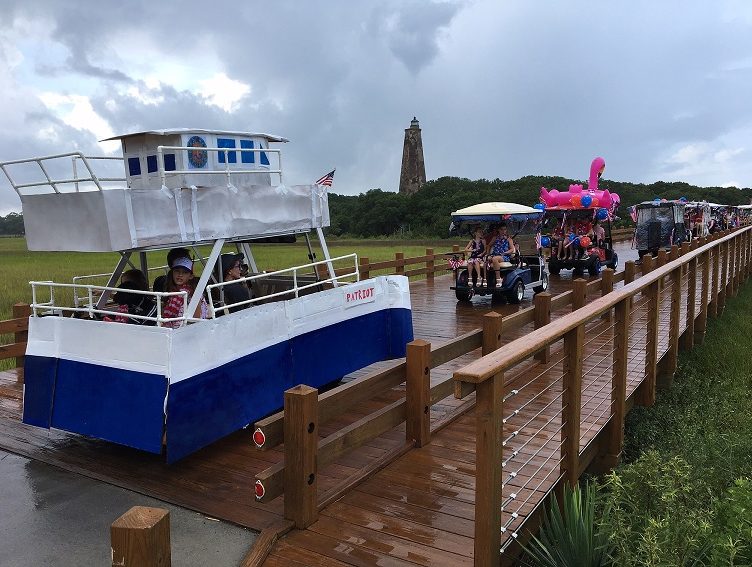 The annual Bald Head Island Golf Cart Parade crosses the bridge and heads toward Old Baldy Lighthouse on July 4