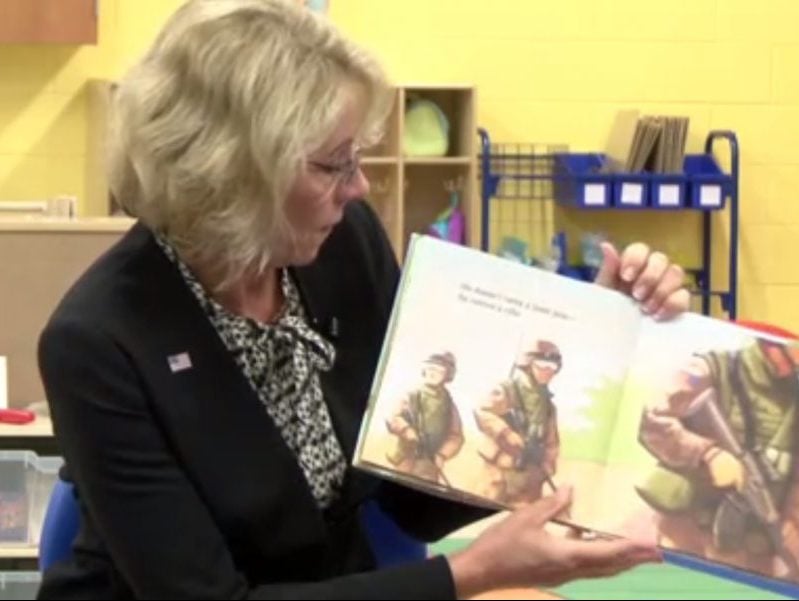 US Education Secretary Betsy DeVos reads to students at a school at Fort Bragg on April 3