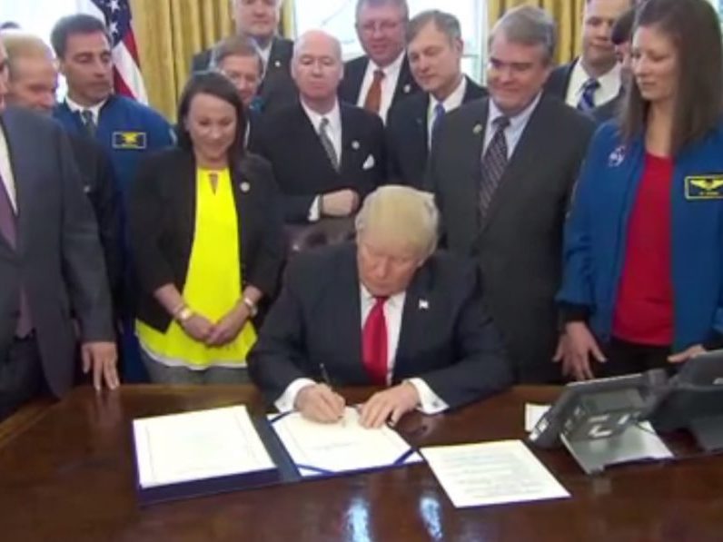 President Donald Trump signs a bill authorizing spending for NASA during a ceremony at the White House on March 21