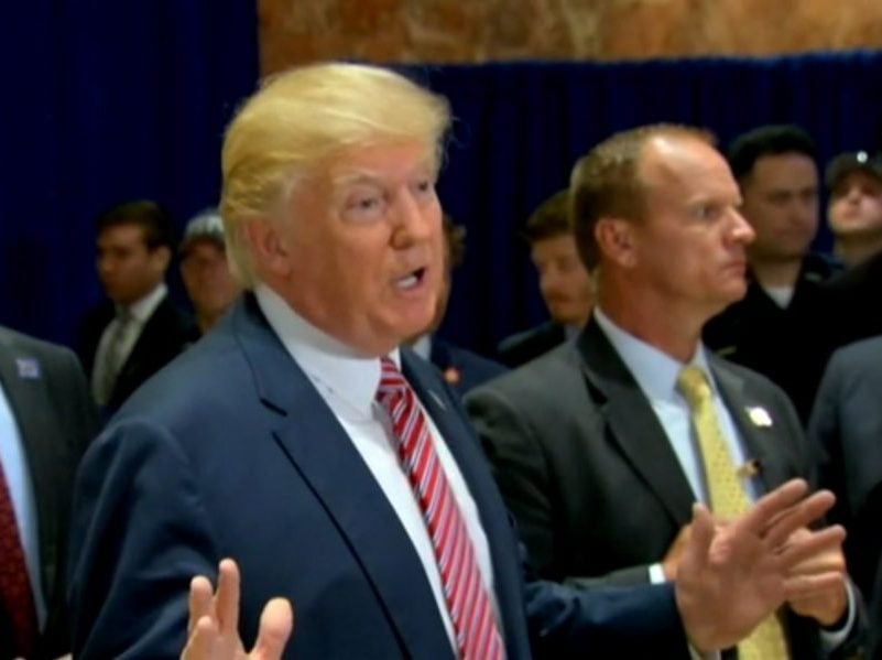 President Donald Trump talks to reporters in the lobby of Trump Tower in New York City on Aug. 15