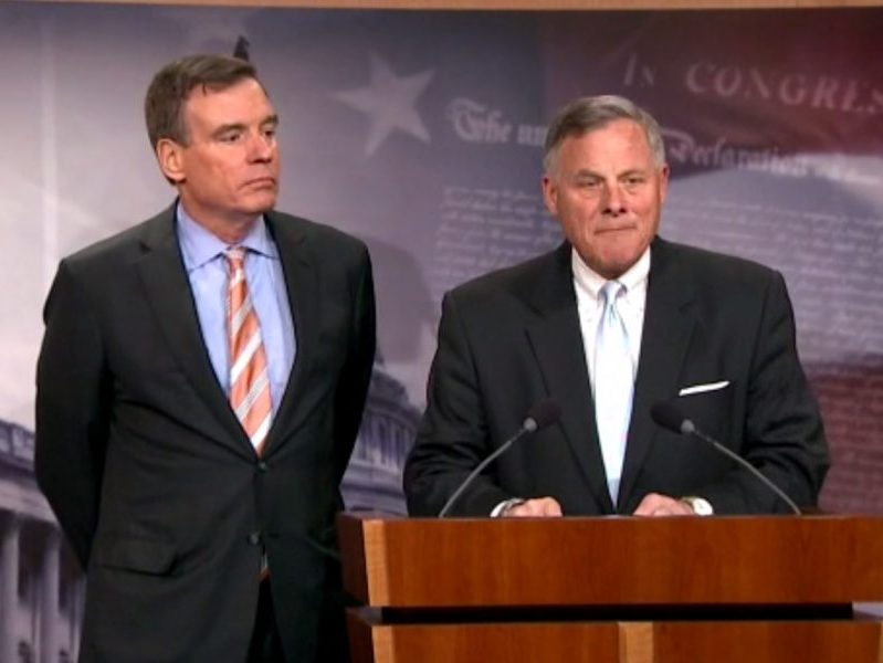Sen. Mark Warner (D-Virginia) and Sen. Richard Burr (R-North Carolina) talk with reporters on March 29