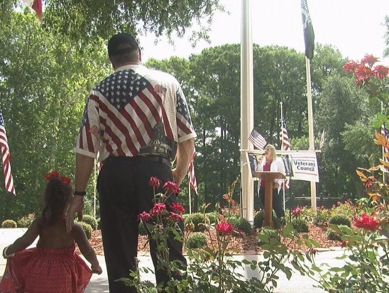 Chairman Frank Roberts holds his granddaughters hand as his daughter sings "God Bless America" on July 4