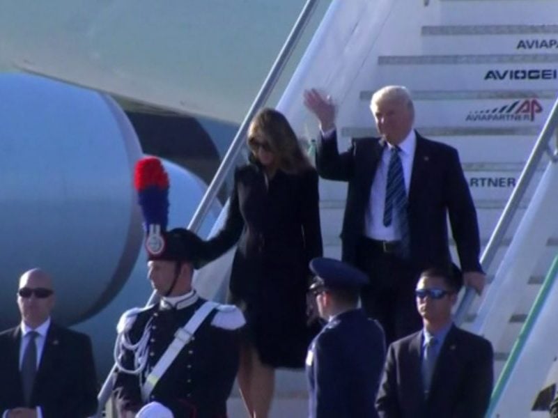 President Donald Trump waves as he and First Lady Melania Trump arrive in Rome on May 23