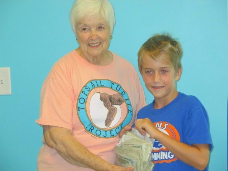 Grayson giving Turtle Hospital Director Jean Beasley donation for turtles