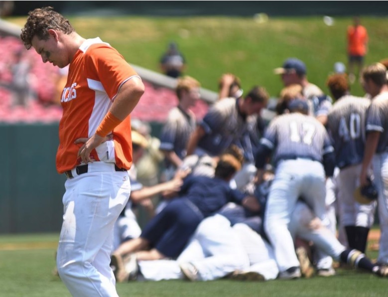 New Hanover's Alex Sniffen walks off the field as T.C Roberson celebrates after beating the Wildcats 10-3 in Game 2 of the 4A State Championship on June 3