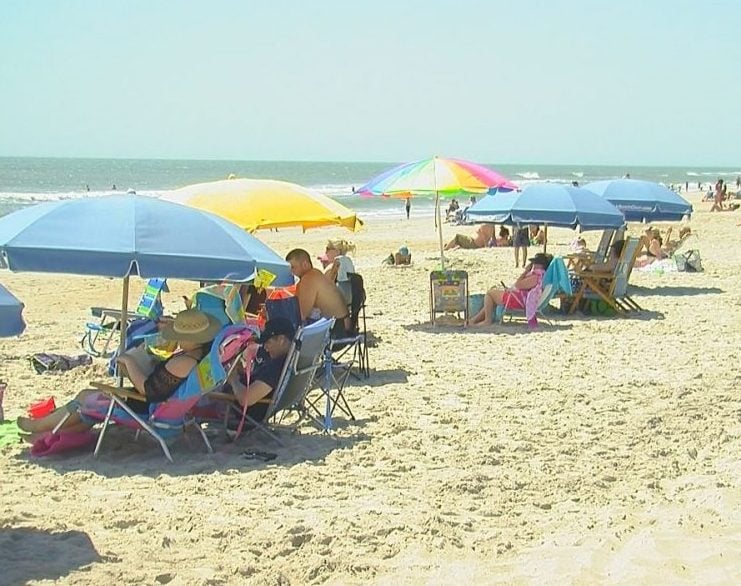 People sitting out on Carolina Beach can use the beach services from Wheel Fun Rentals and Pleasure Island Rentals