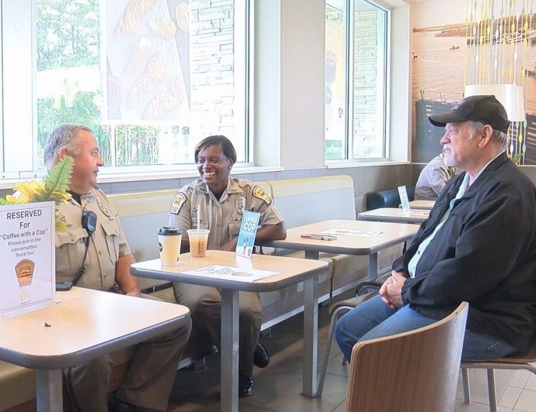 Officers with New Hanover County Sheriff's office speaking with a citizen for Coffee with a Cop Day on October 4