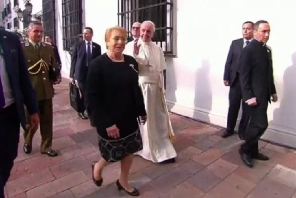 Pope Francis waves to onlookers as he walked with President Michelle Bachelet in Santiago