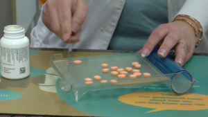 A pharmacist fills a prescription.