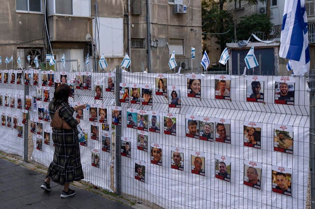 A woman looks at photographs of hostages who were abducted during the October 7th Hamas attack on Israel.