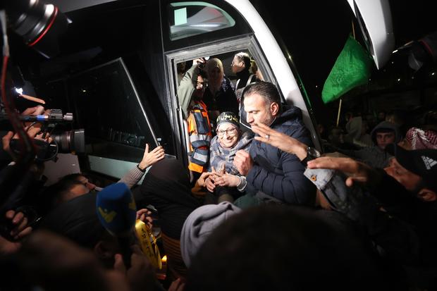 A man carries a flag as Palestinians released from Israeli jail arrive in Beitunia, Ramallah, West Bank, by a bus belonging to the International Committee of the Red Cross.