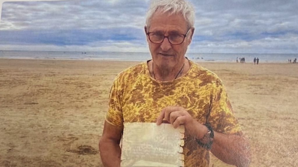 A French fisherman holds a found letter, written 26 years ago by a child in Massachusetts.