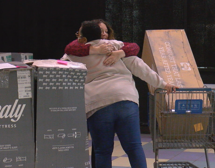 Going Beyond the Pink Founder Kara Kenan hugs one of 44 breast cancer survivors that received a free mattress