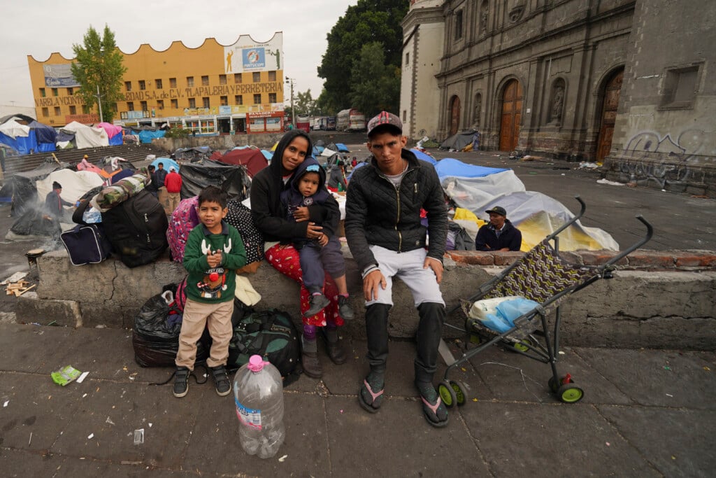 The Aguilar Bastida family, from Venezuela, sit outside the Church of Santa Cruz y La Soledad where migrants camp out in Mexico City.