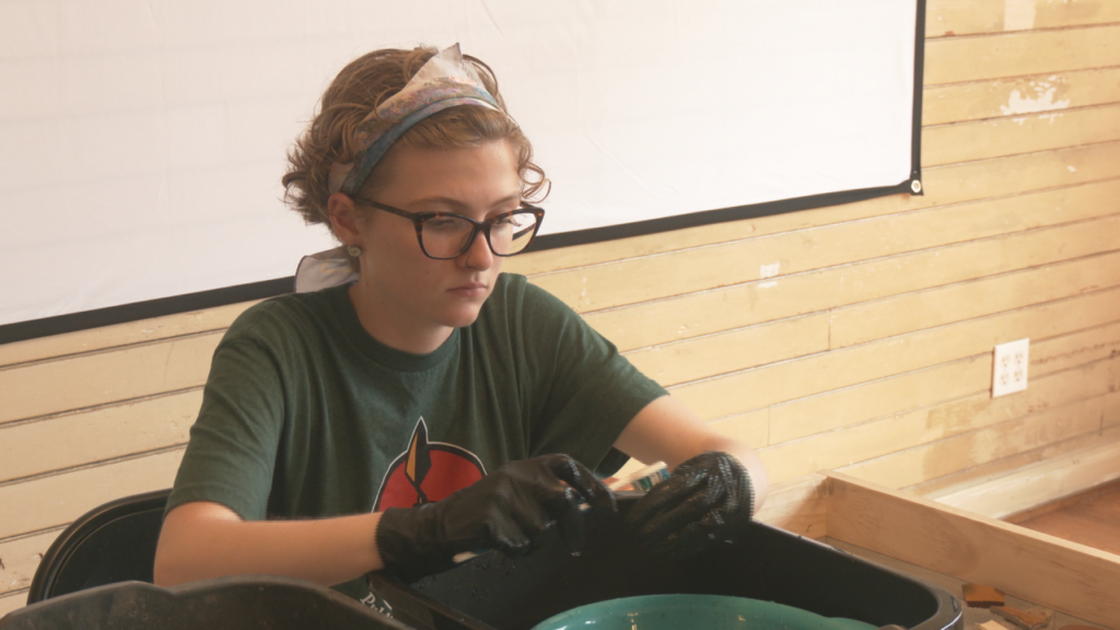 Issy Gee cleans ceramic fragments found in Wilmington dating back to the 18th century. (Photo:Nate Mauldin/WWAY)