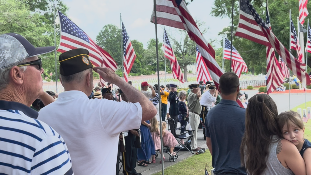Veterans salute as the national anthem is played on a tumpet. (Photo:Nate Mauldin/WWAY)