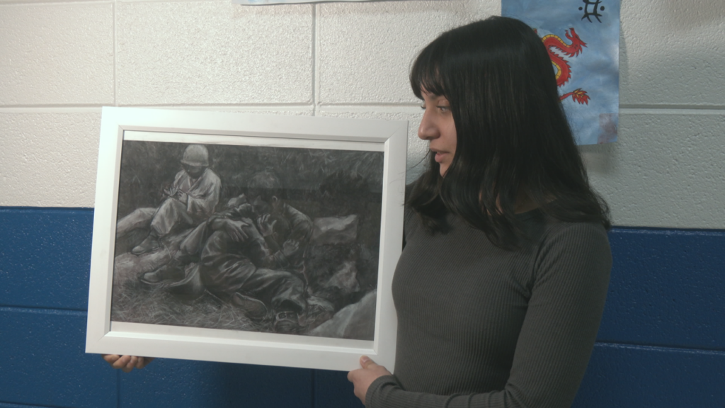Senior Liliana Arroyl holds up her charcoal artwork that won the award for North Carolina in a national art competition. (Photo: Nate Mauldin/WWAY)