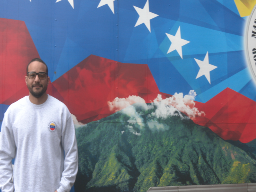 Miguel Navarro posing next to his food truck, Made in Venezuela