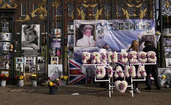 A floral arrangement and messages of remembrance for Princess Diana are displayed on the gates of Kensington Palace,