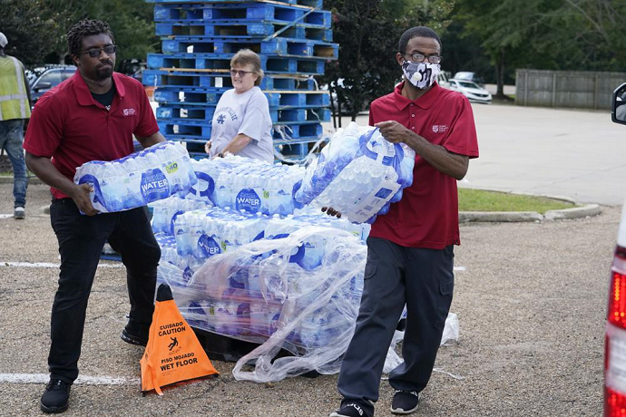 Salvation Army members carry cases of water to a waiting vehicle in Jackson, Miss., Wednesday, Aug. 31, 2022.