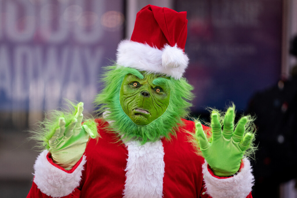 A Person Dressed As The Grinch In Times Square Poses For Photos In New York